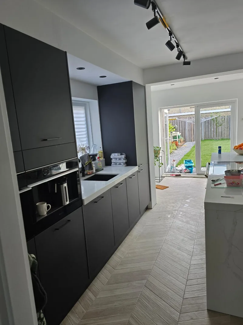 Opgeleverde keuken met matte fronten, wit werkblad en openslaande tuindeuren